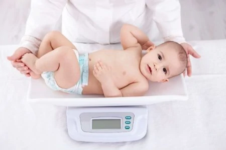 Baby boy being weighed on a scale