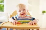 Cute baby boy wearing a bib while eating