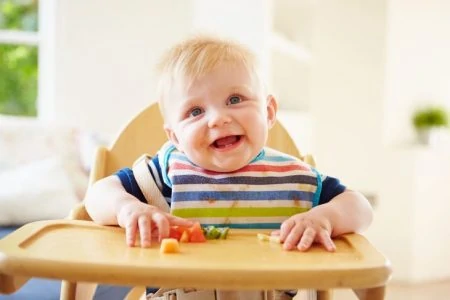Cute baby boy wearing a bib while eating