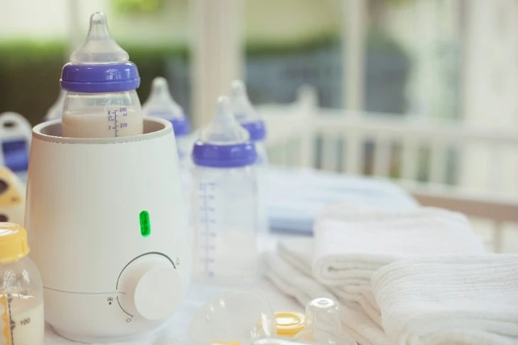 Baby bottle warmer on the kitchen counter warming a bottle of milk
