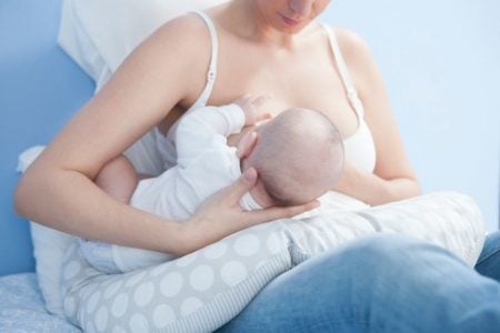 Mother breastfeeding with nursing pillow