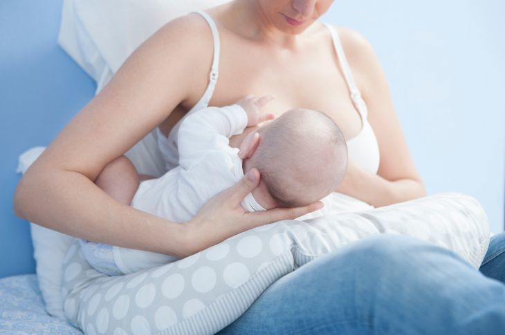 Mother breastfeeding with nursing pillow
