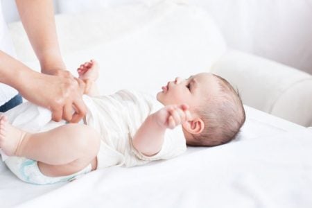 Mother changing her new born baby's disposable diapers