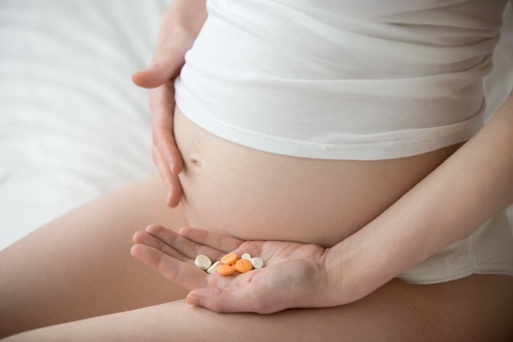 Pregnant woman taking her prenatal vitamins