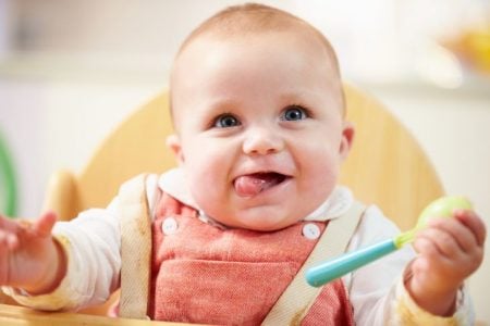 Cute baby eating with a spoon