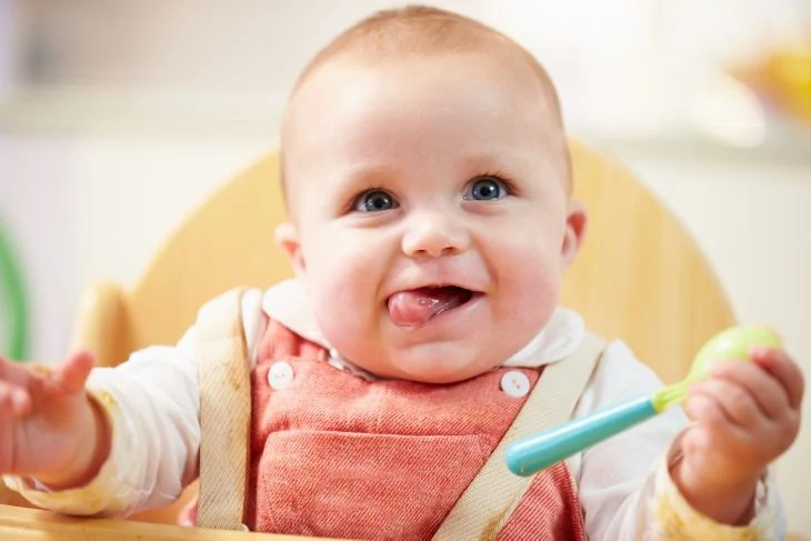 Cute baby eating with a spoon
