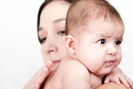 Mother burping her baby over her shoulder