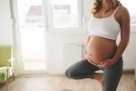 Pregnant woman practising yoga wearing maternity yoga pants