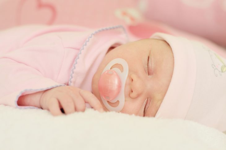 Baby sleeping while soothing on a pacifier