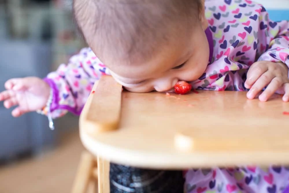 Baby girl sitting in a dirty high chair