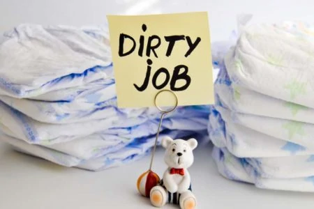 Stack of disposable diapers with a sign that reads "Dirty Job"