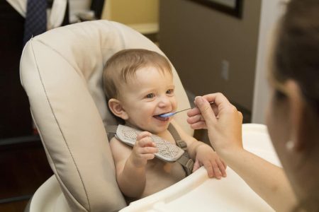 Baby eating sitting in high chair