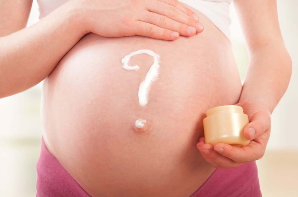 Woman performing belly mapping to decide if baby is head down