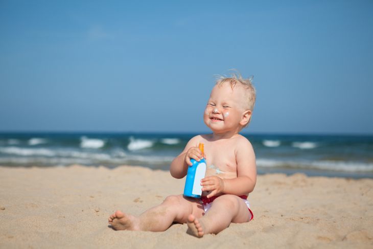 Baby on the beach wearing sunscreen