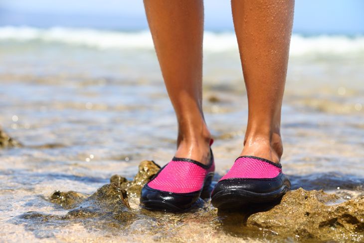 Girl wearing water shoes at the beach