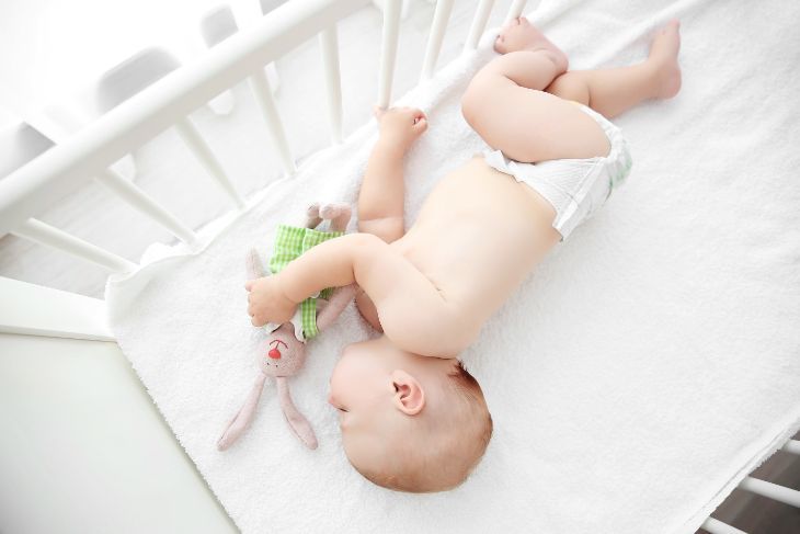 Newborn baby sleeping in a white crib
