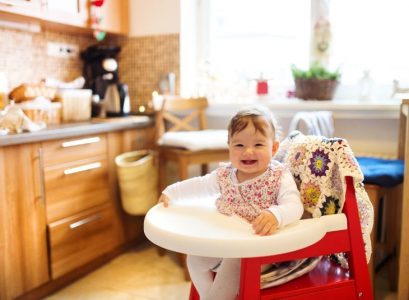 Baby girl sitting in a folding high chair