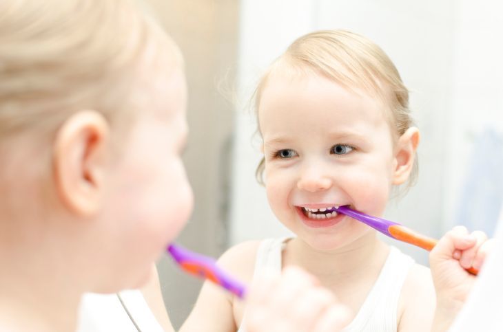 Little girl brushing her teeth in bathroom