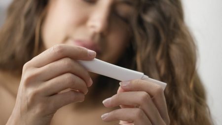 Woman looking at an expired pregnancy test