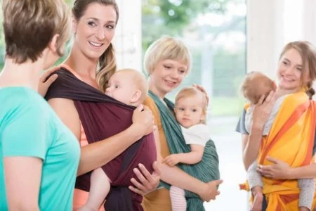New mothers exercising wearing baby carriers