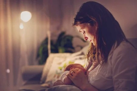 Woman breastfeeding her baby at night