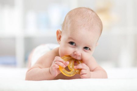 Baby boy chewing on a teething toy