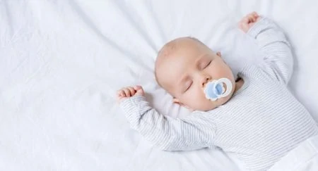 Baby sleeping while sucking on a pacifier