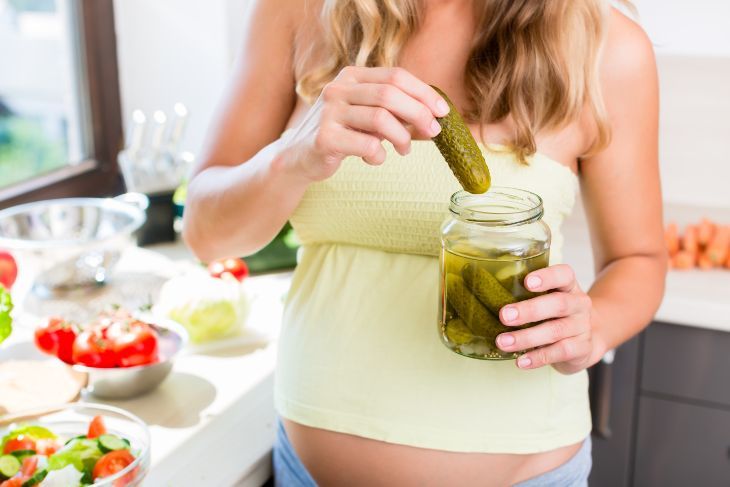 Woman with pregnancy cravings eating a pickle