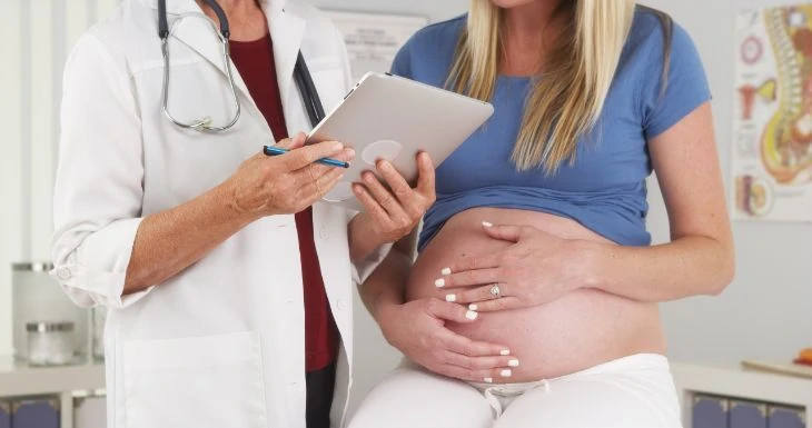 Pregnant women in the doctors office learning about watery discharge