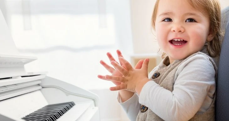 Happy toddler learning to play the piano