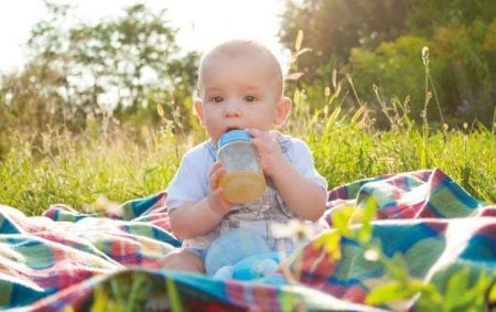 Baby drinking juice from a sippy cup