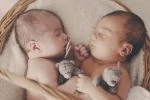 Twins sleeping together in a crib