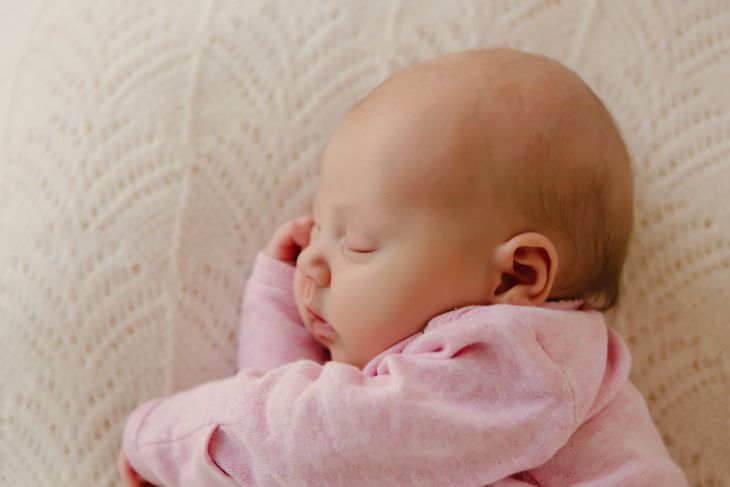 baby rolling on side in bassinet