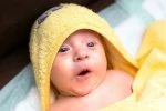 Baby wrapped in yellow bath towel