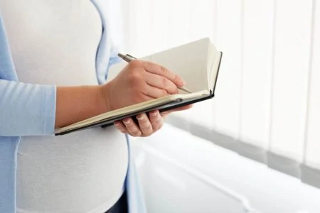 Pregnant woman writing in a journal