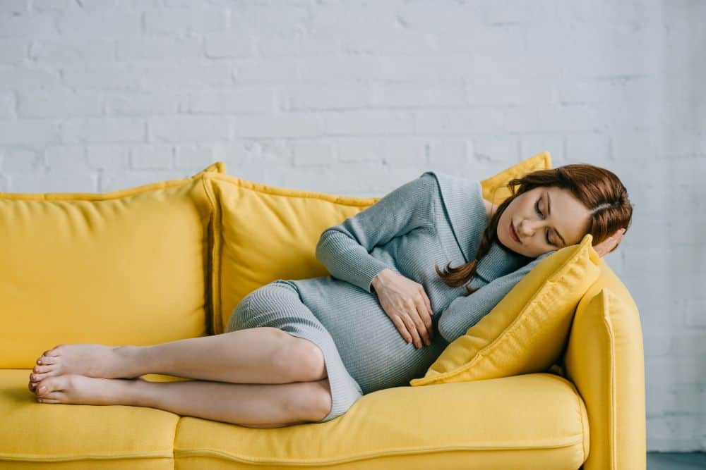 Pregnant woman sleeping on the couch and dreaming