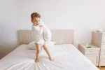 Toddler playing on the bed