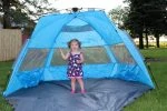 Baby girl standing in a beach tent
