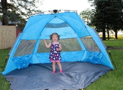 Baby girl standing in a beach tent