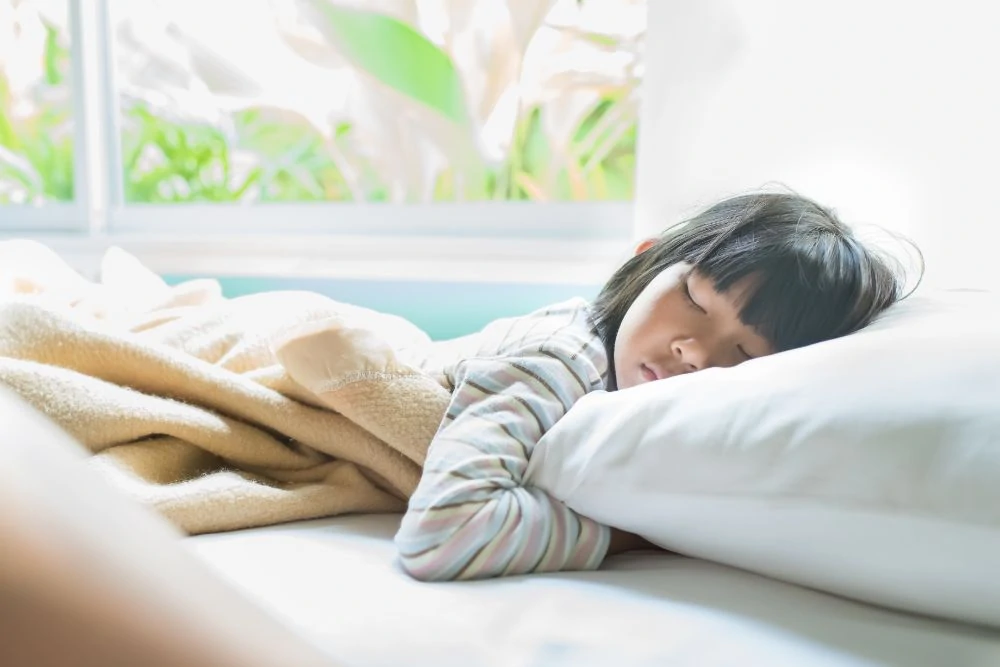 Toddler hugging a pillow while sleeping