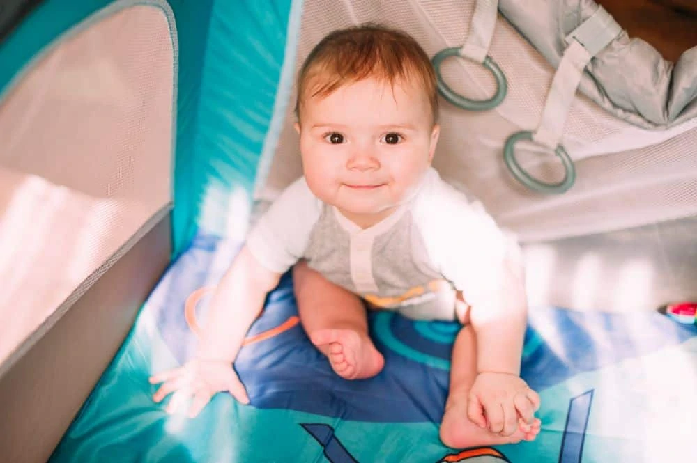 Young baby in a travel crib