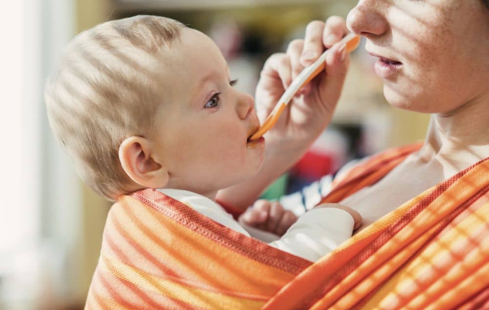 Baby eating while in a baby carrier