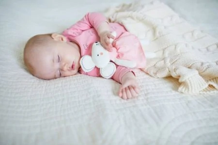 Baby sleeping with a security blanket