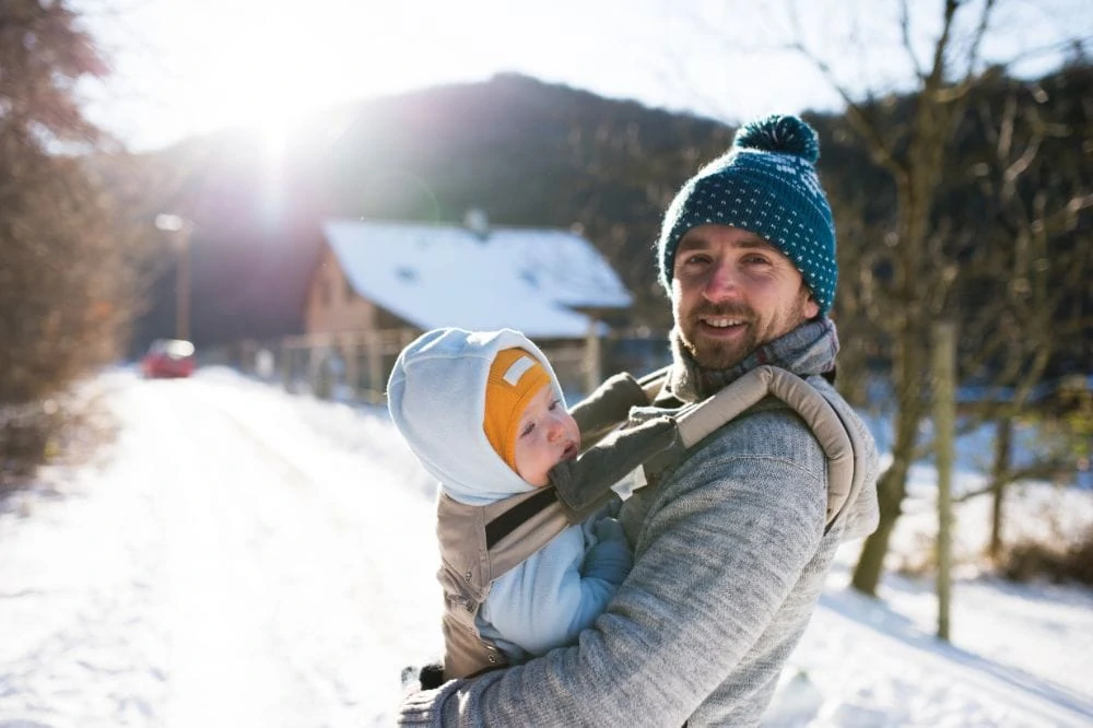 Dad wearing his baby in a carrier during winter