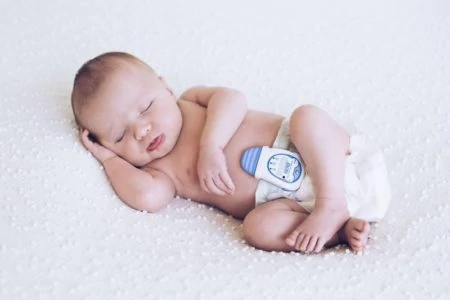 Sleeping baby wearing a breathing monitor