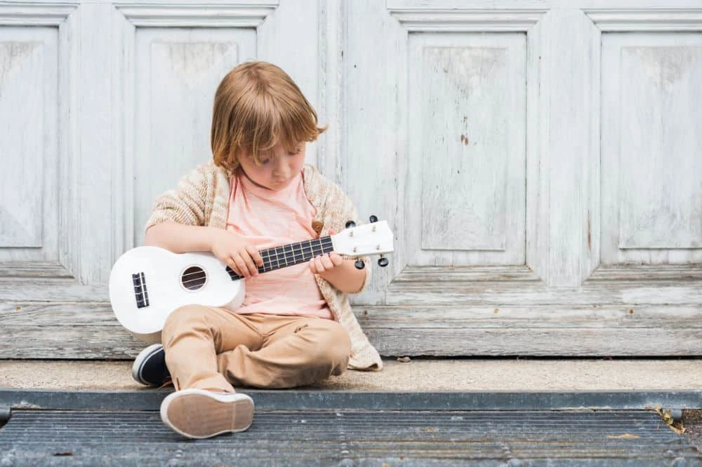 Little boy playing the ukelele