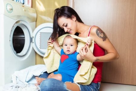 Mother doing laundry with her baby