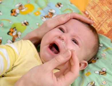 Crying baby given nose drops