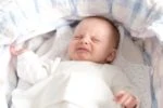 Crying baby in a bassinet