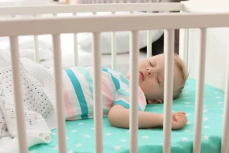 Baby boy sleeping in a crib
